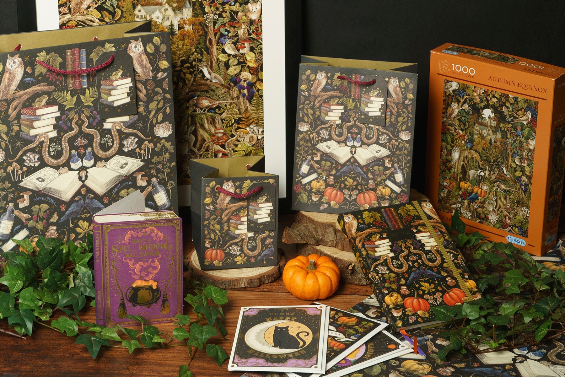 A table laid out with autumn gifts such as a wall art print, gift bag, cards, and jigsaw puzzle.