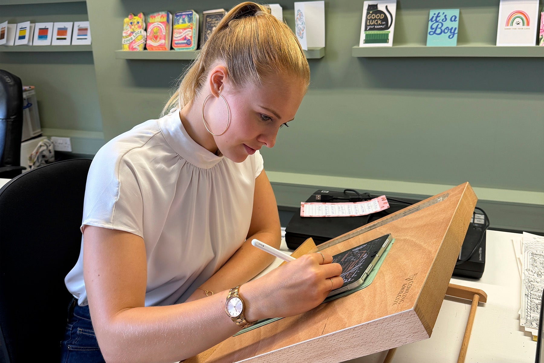 Poppy Roberton working on a new collection of cards at a desk.