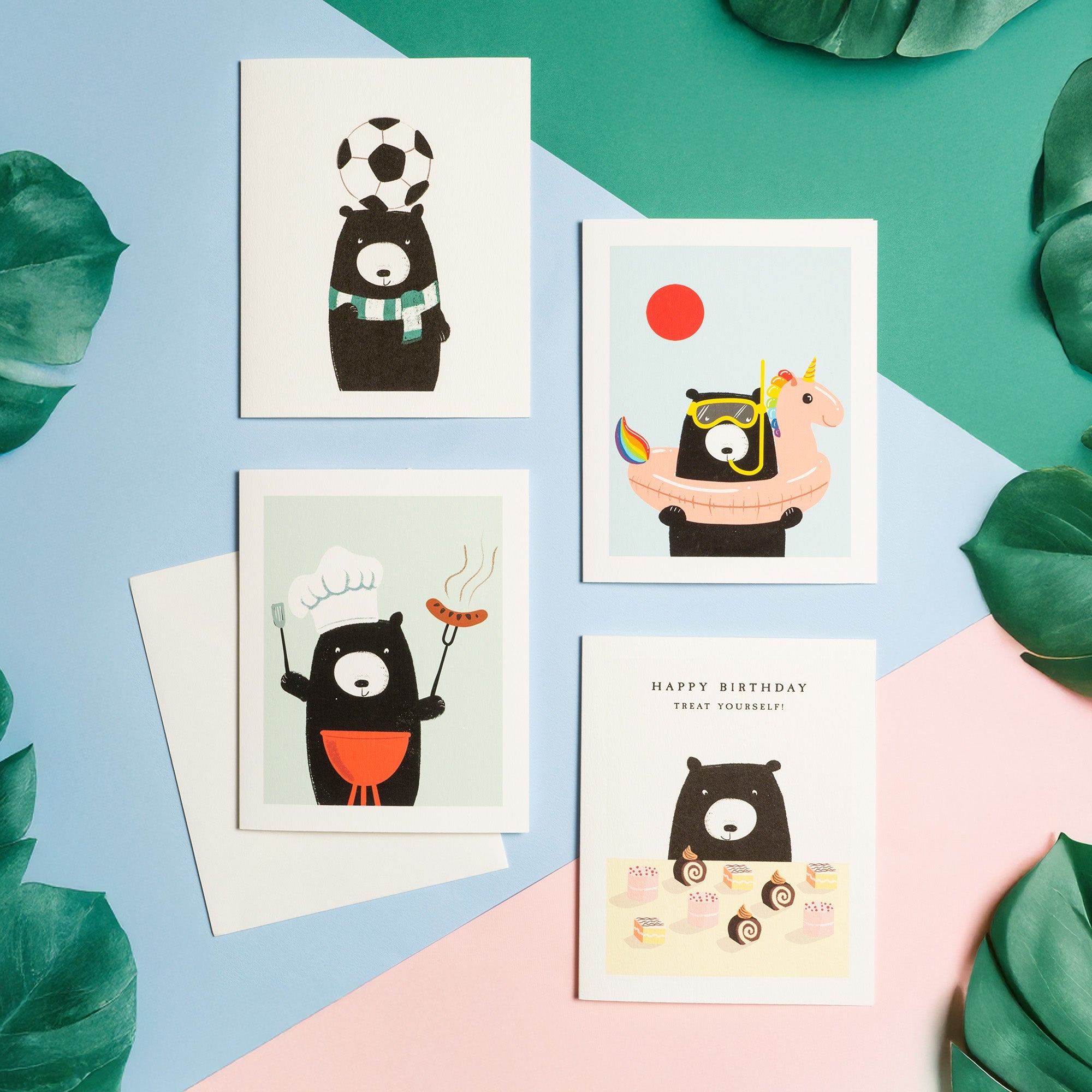A collection of adorable Bear birthday cards laid out on a colourful background, surrounded by leaves.