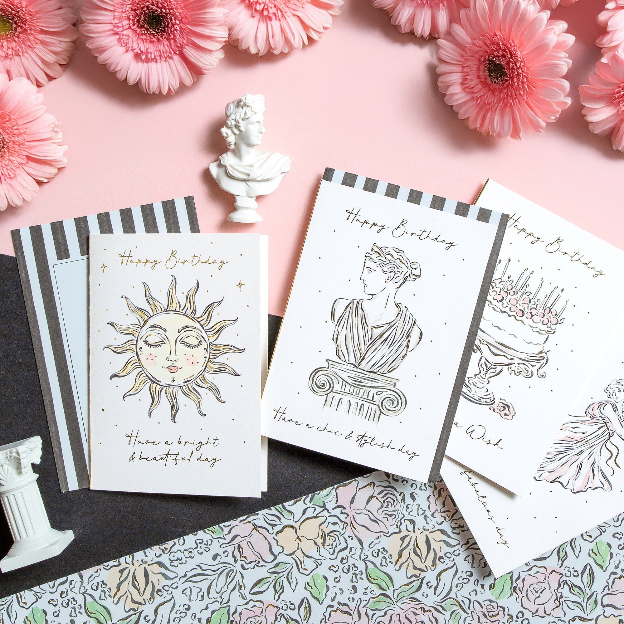 Elysian birthday cards surrounded by gift wrap and flowers.