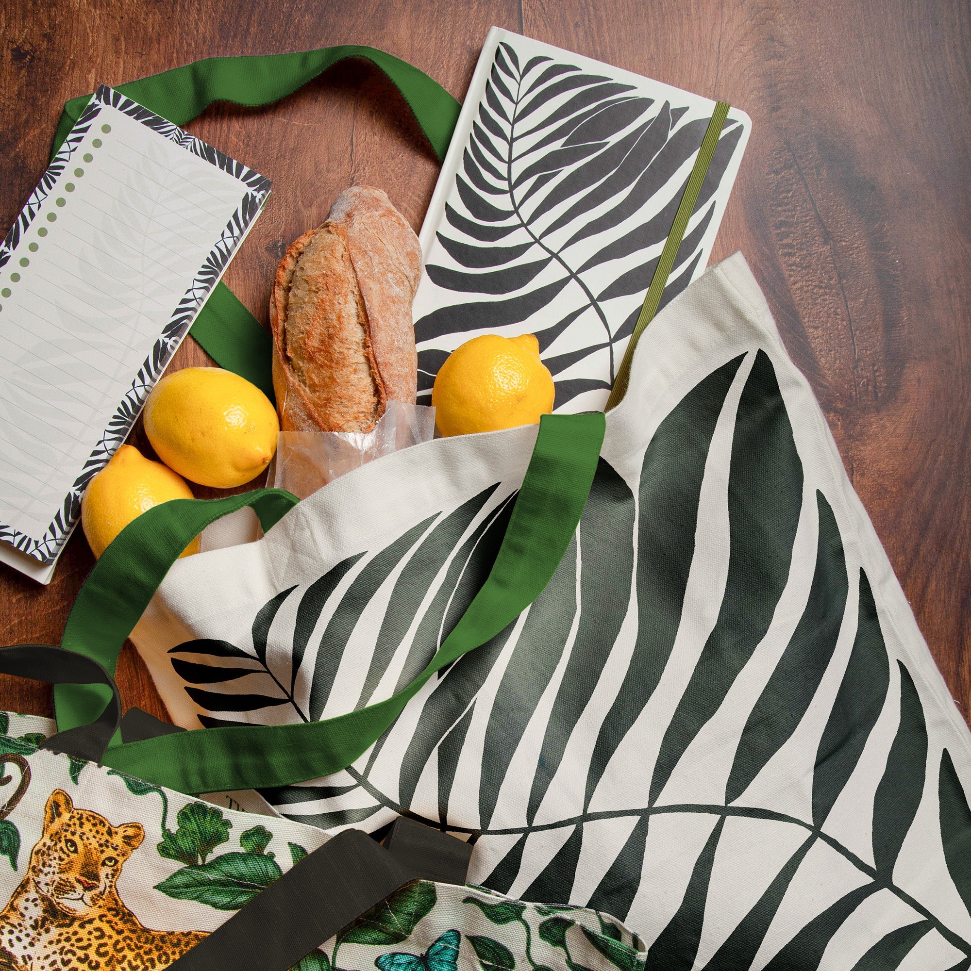 Gifts of tote bags, notebooks, magnetic list pads on a wooden table.