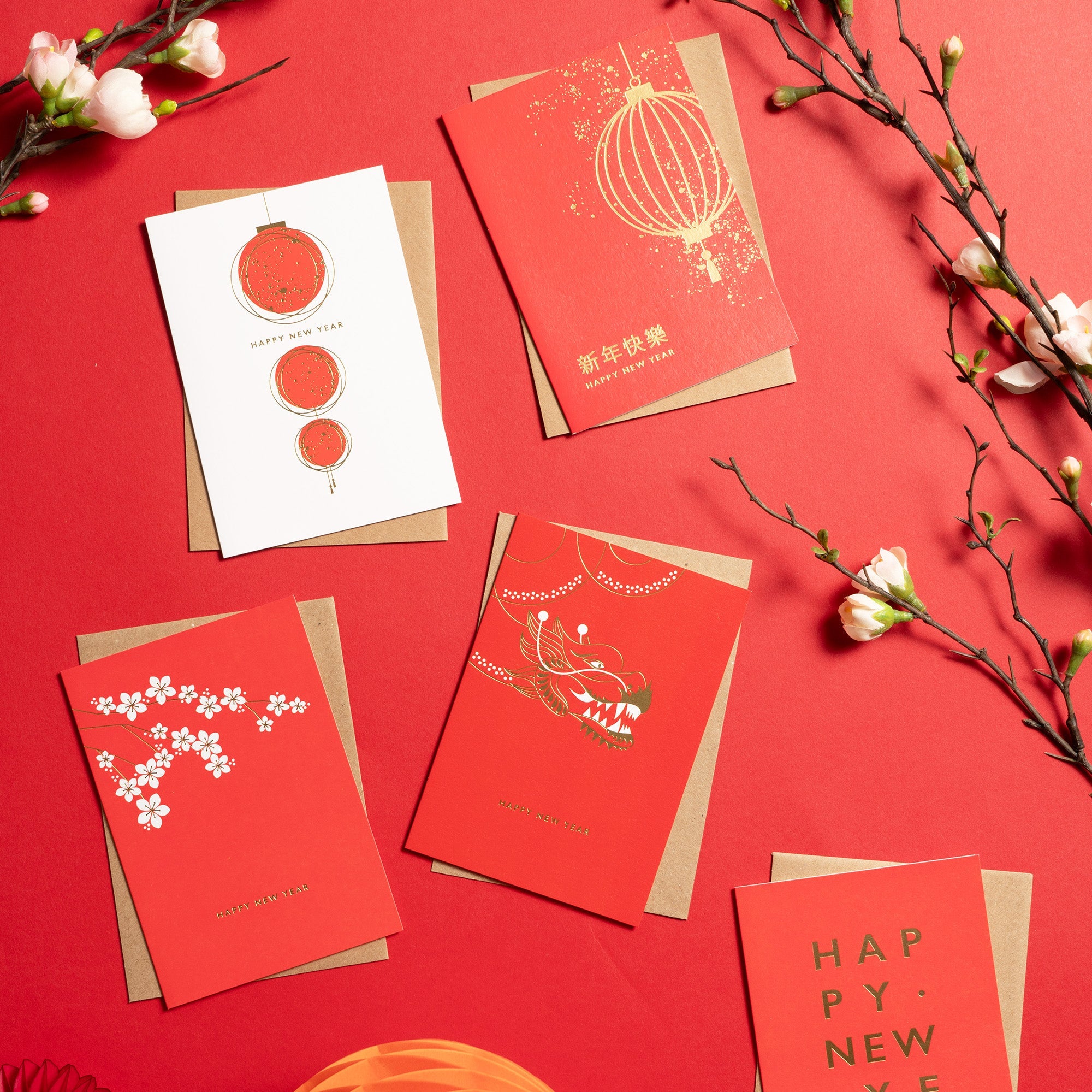A beautiful collection of Chinese New Year cards is laid out on a red background.