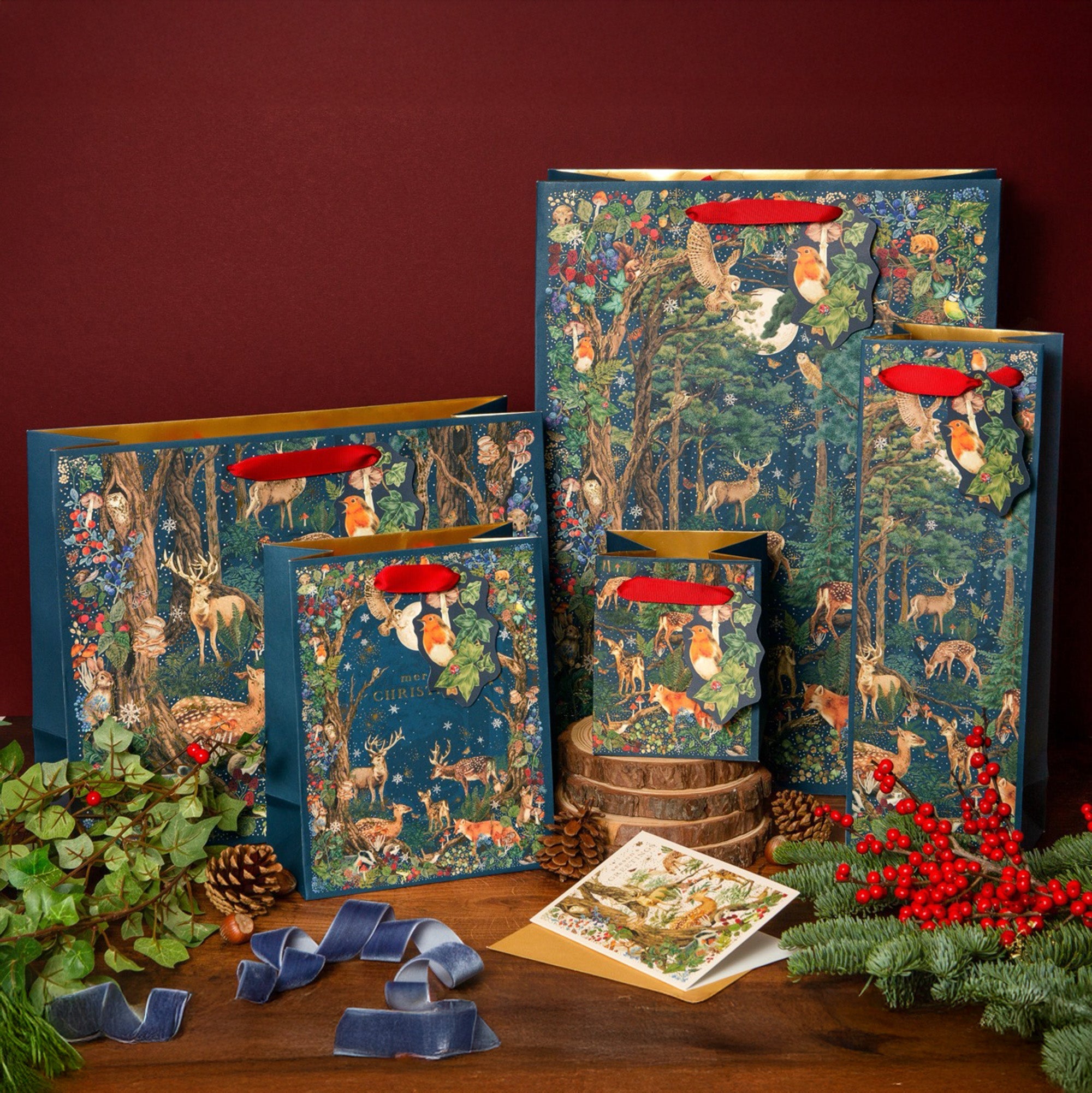 A selection of gift bags of all sizes featuring a midnight woodland scene.