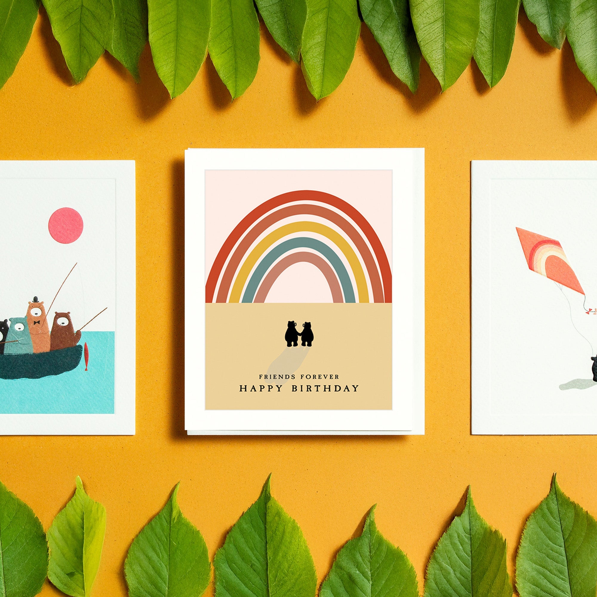 A selection of cards laid out with foliage, including a friendship card.