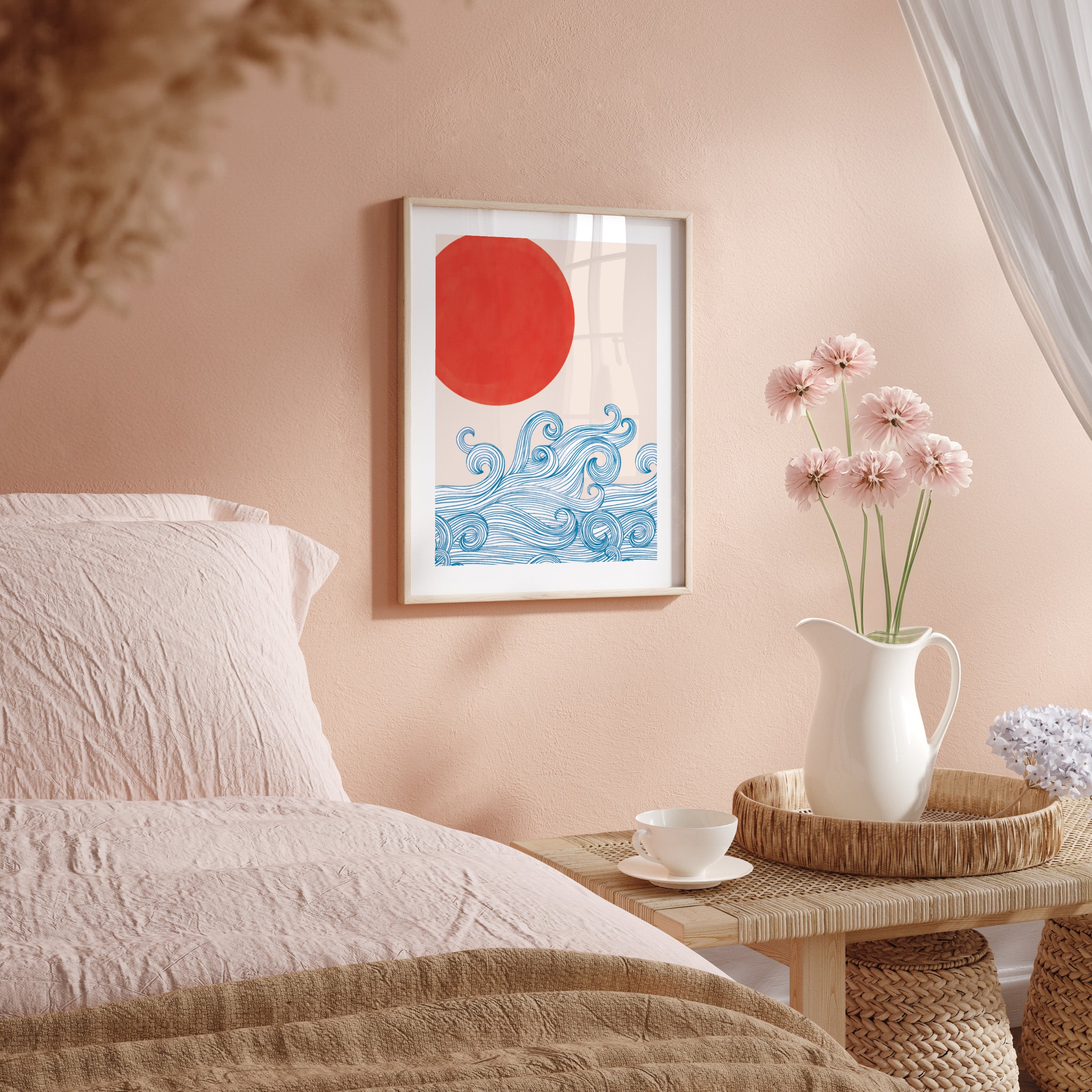 Framed artwork with a red circle and blue waves on a peach wall above a bed.