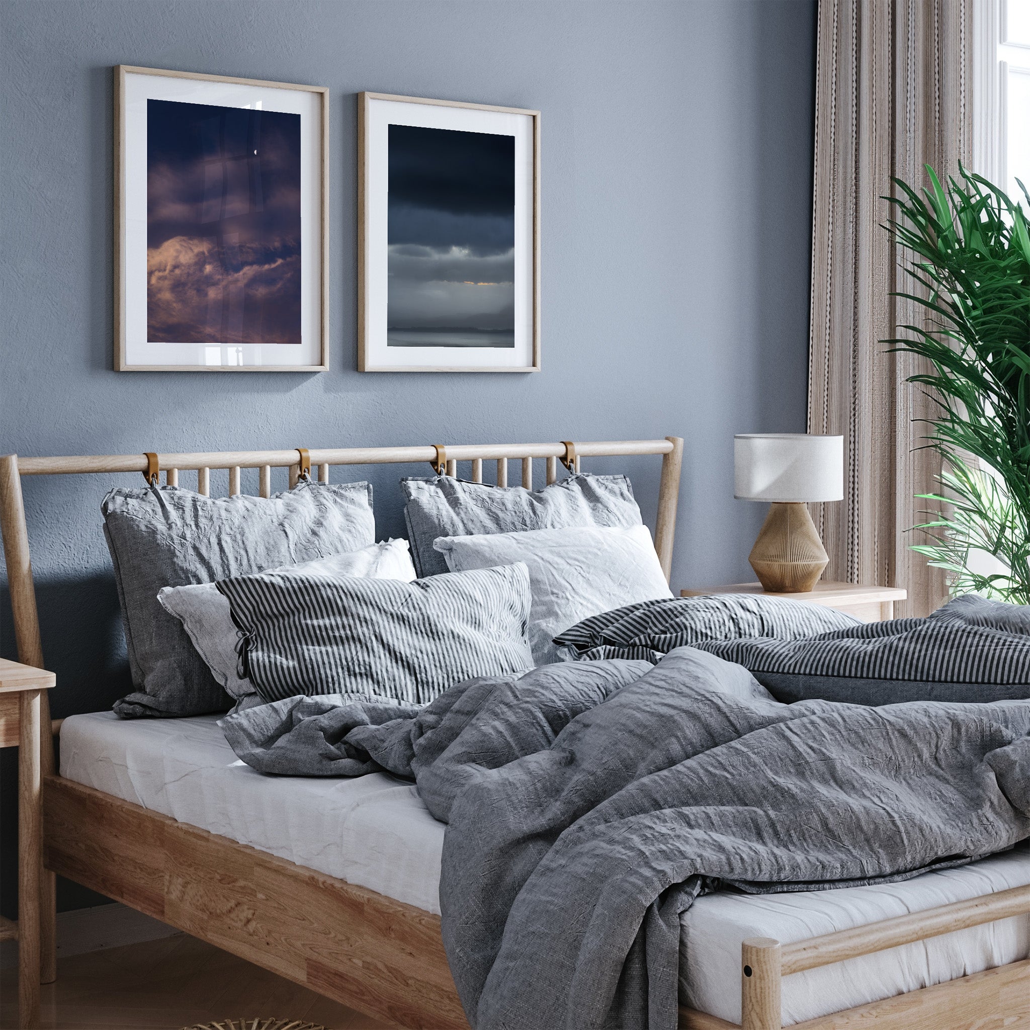 Framed photography art prints featuring clouds and the ocean, hanging above a bed in a bedroom.