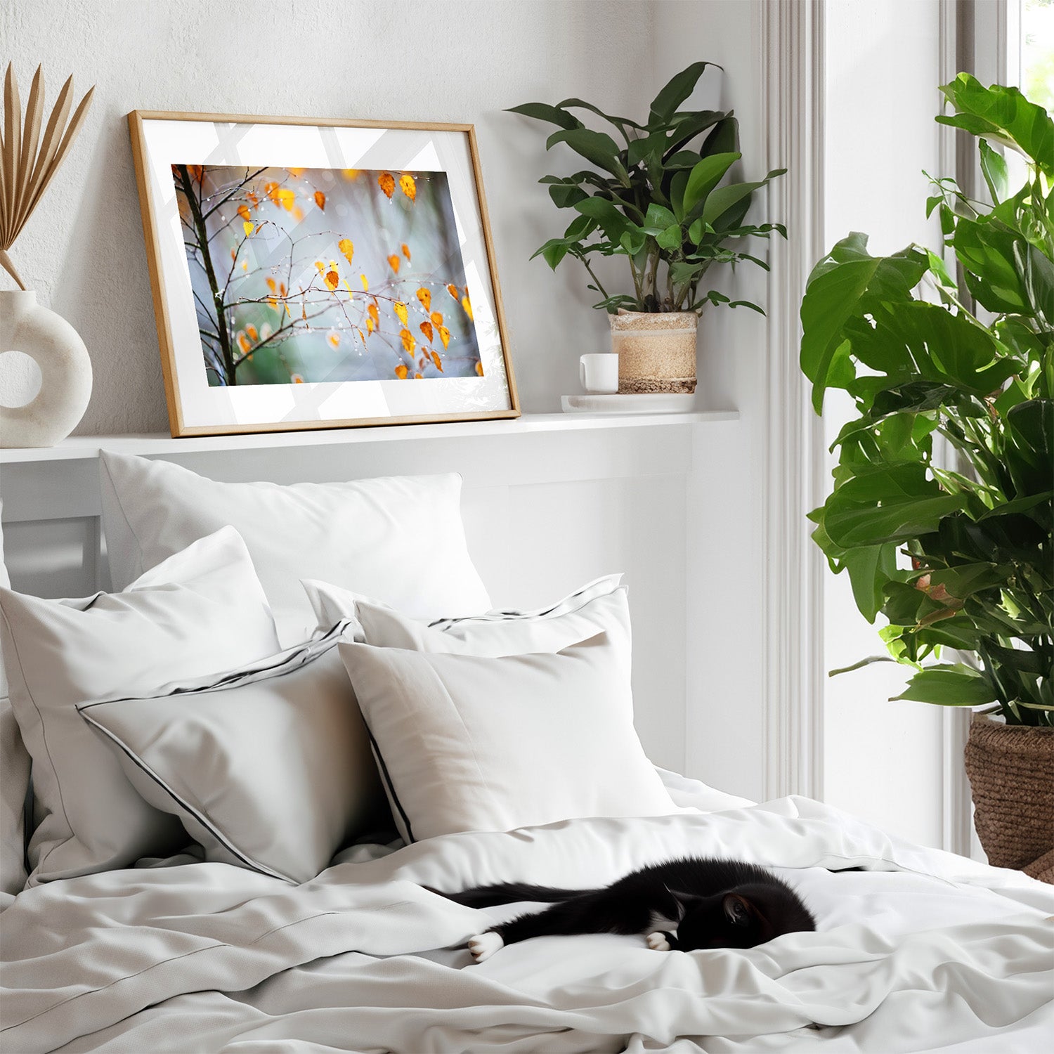 Framed photography art print featuring an Autumnal tree dripping with frost, perched on a shelf above a bed, where a cat is sleeping.