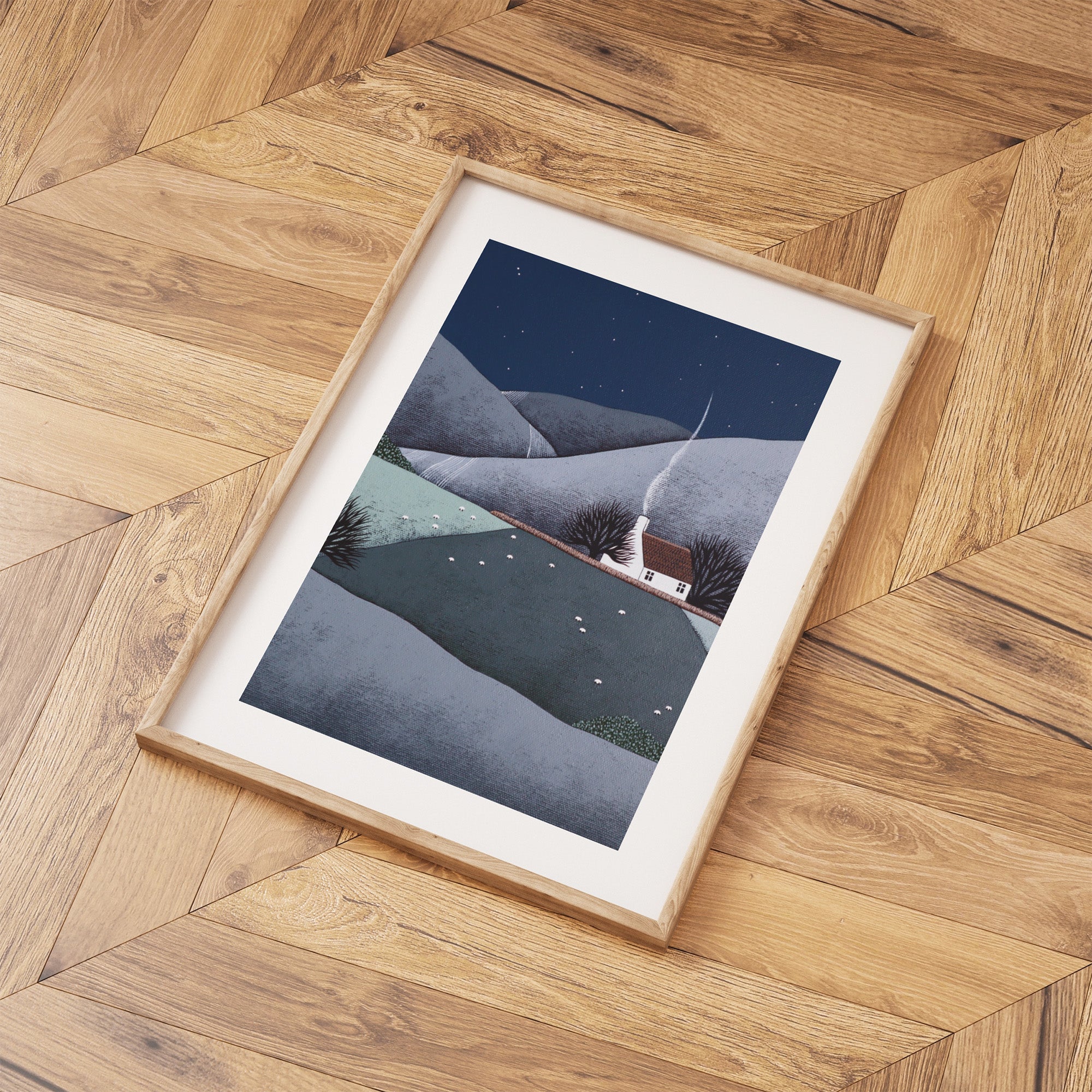 Framed artwork of a mountain landscape on a wooden floor.
