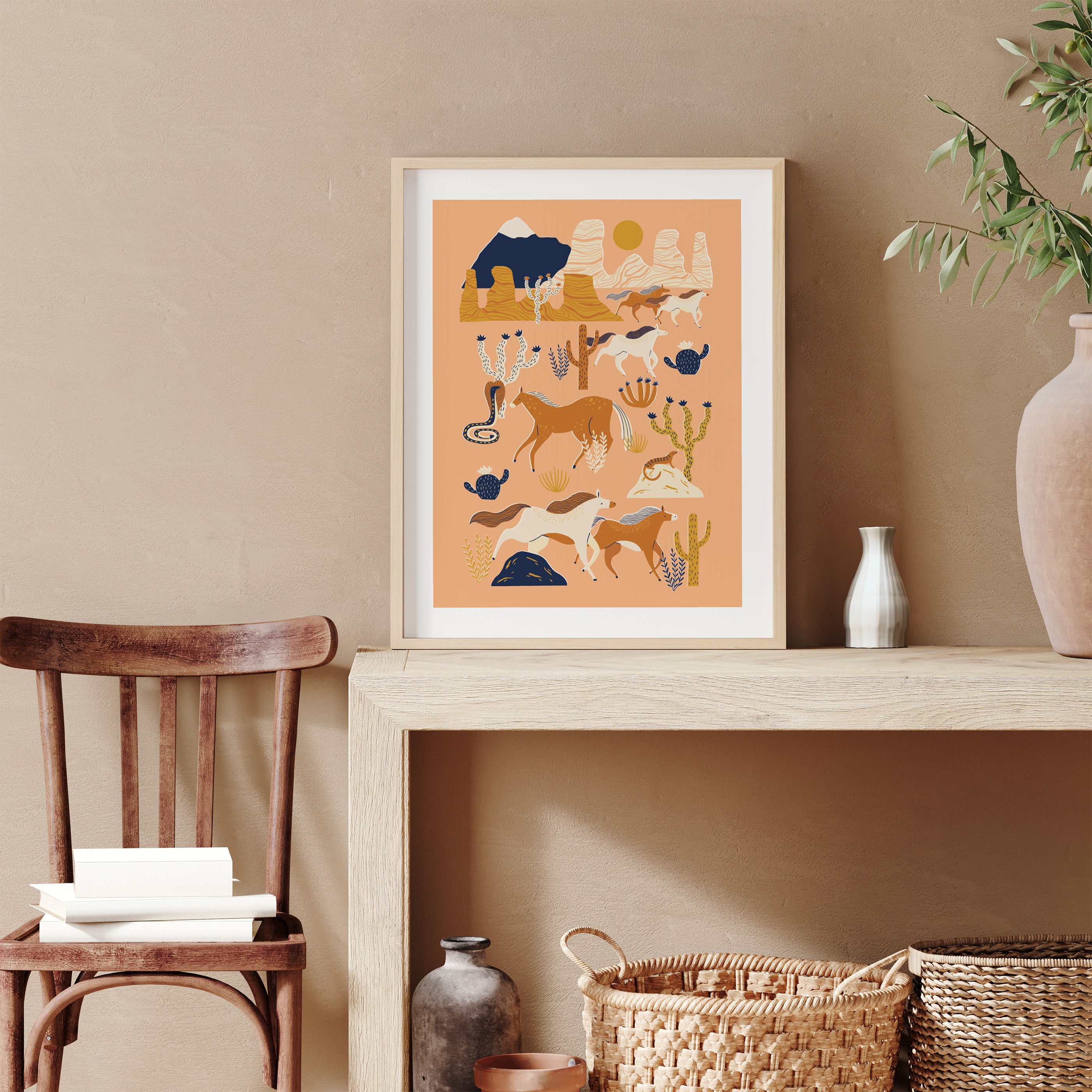 Framed artwork on a shelf with a chair and decorative items in a room.