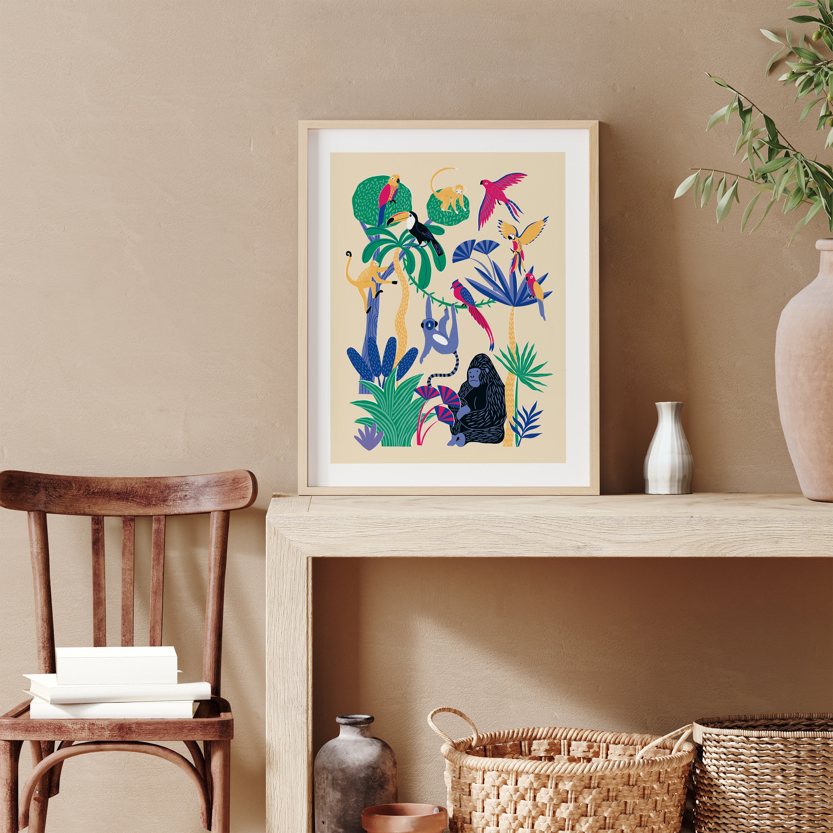 Framed colorful artwork of birds and plants on a beige wall with a wooden chair and decorative items.