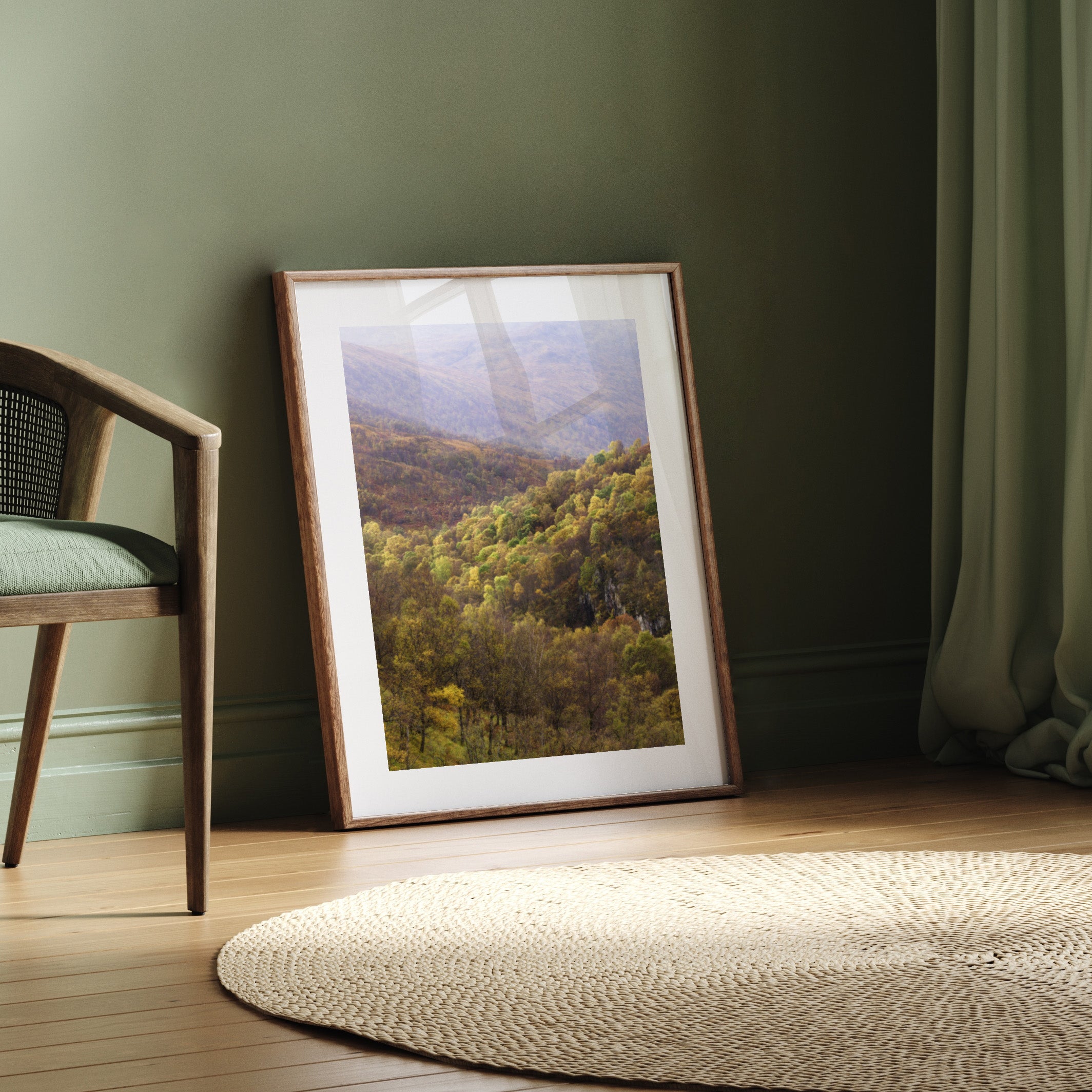 Framed landscape print on a wall next to a chair and rug.
