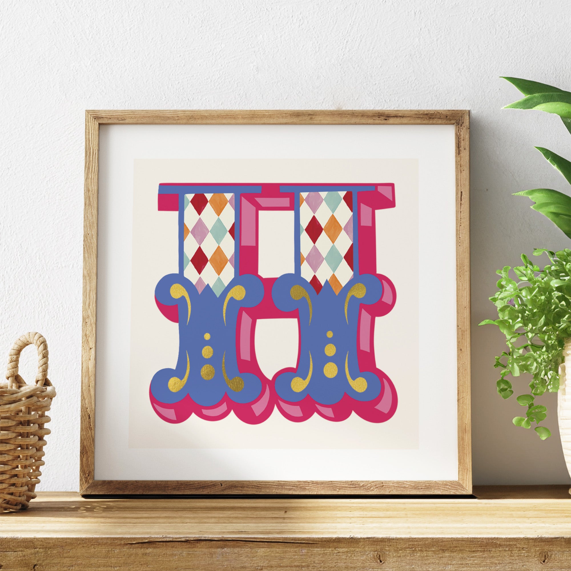 Framed colourful letter 'H' artwork on a shelf with a plant in the background.