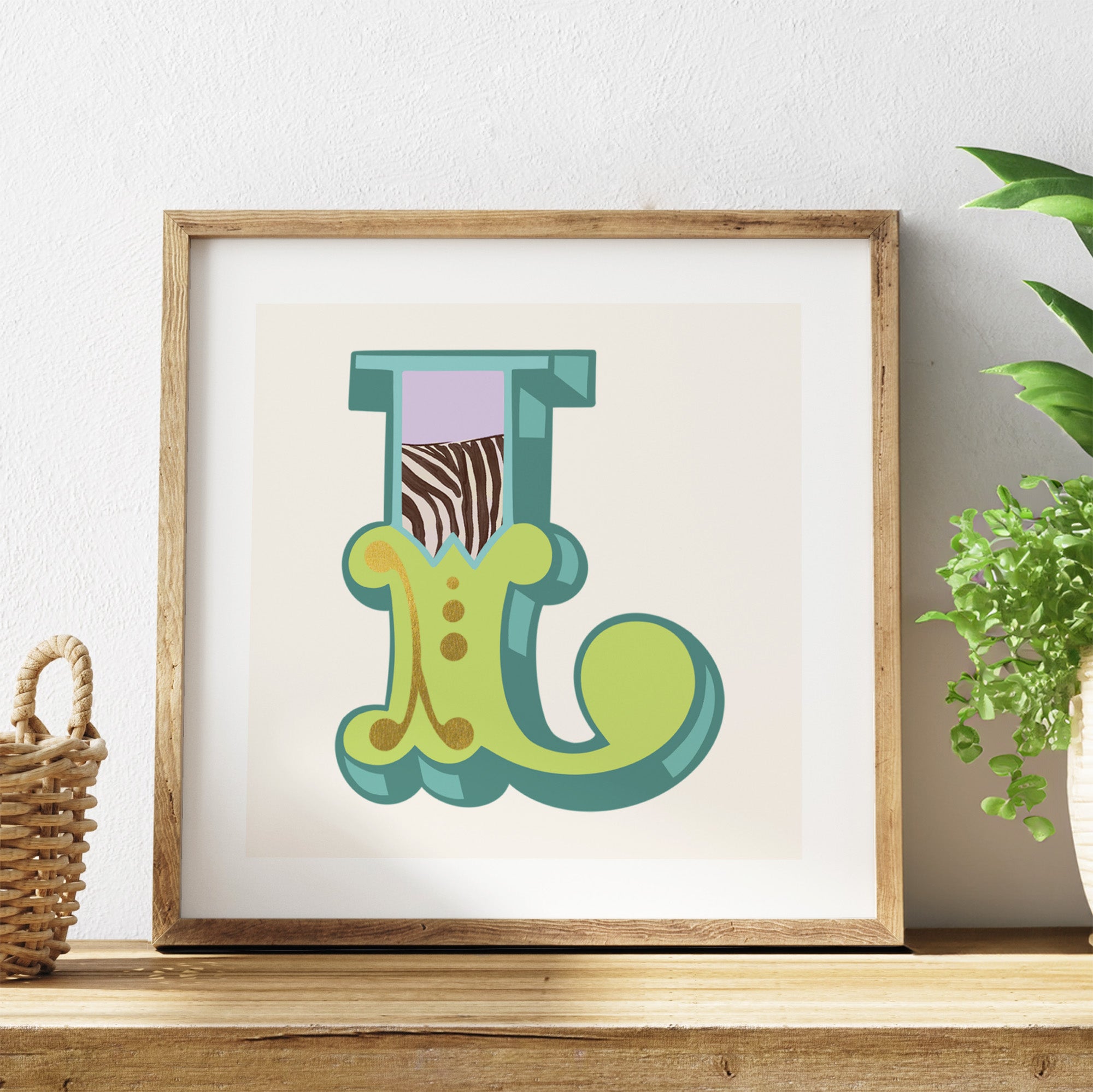 Framed artwork of a colourful letter 'L' on a shelf with a plant in the background.