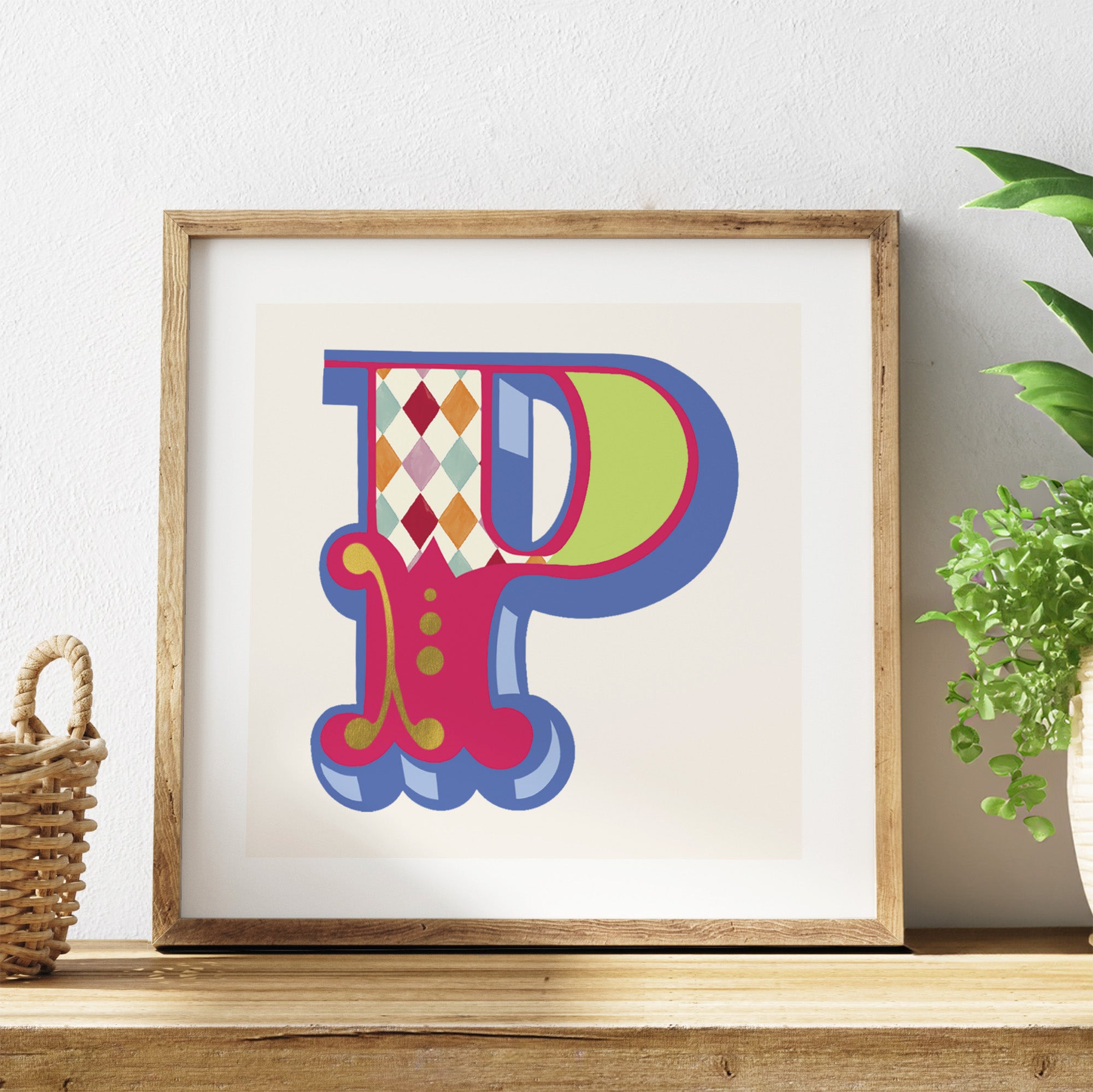 Framed colourful letter 'P' artwork on a shelf with a plant in the background.