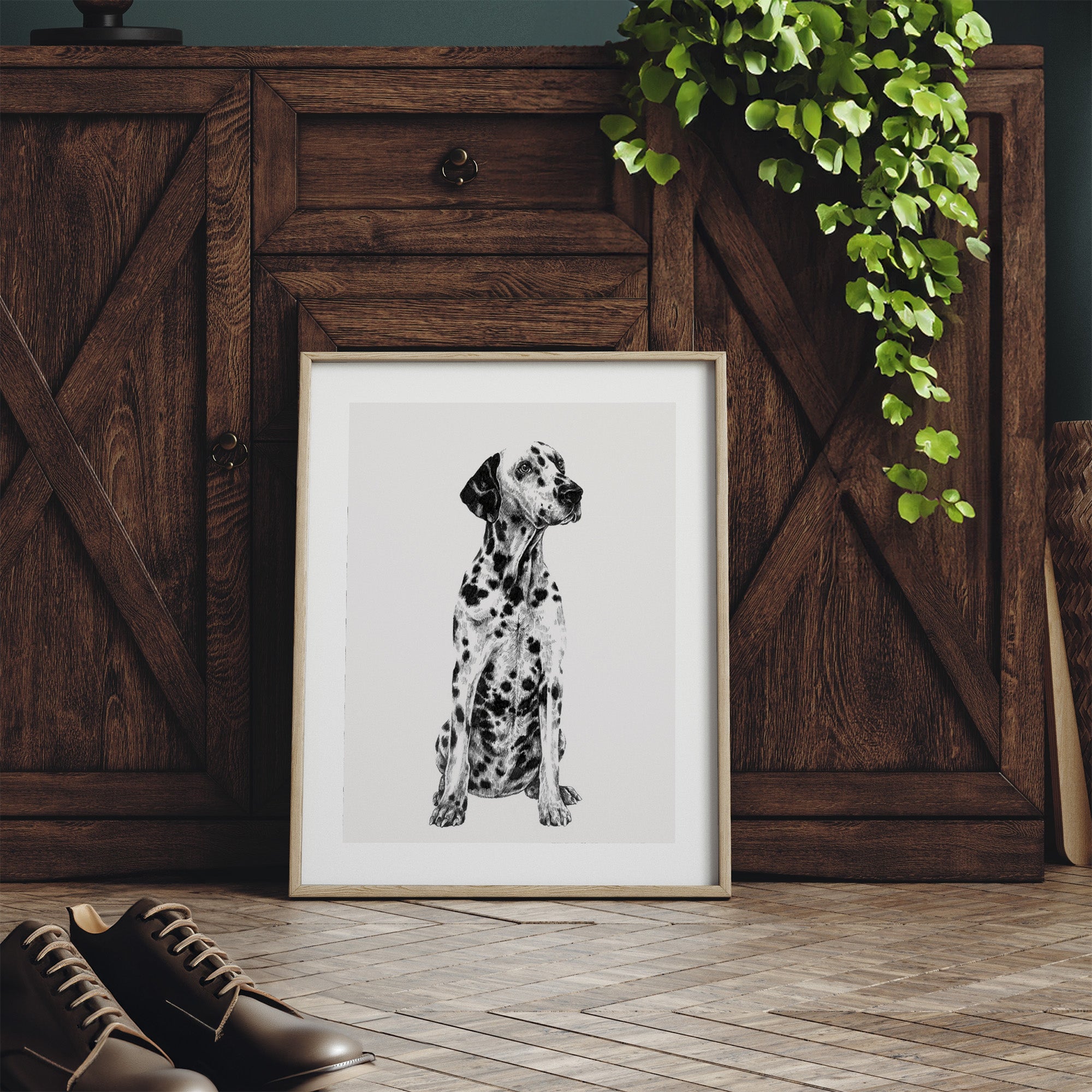 Framed black and white illustration featuring a detailed drawing of a Dalmatian dog. Print is leaning on a dresser.