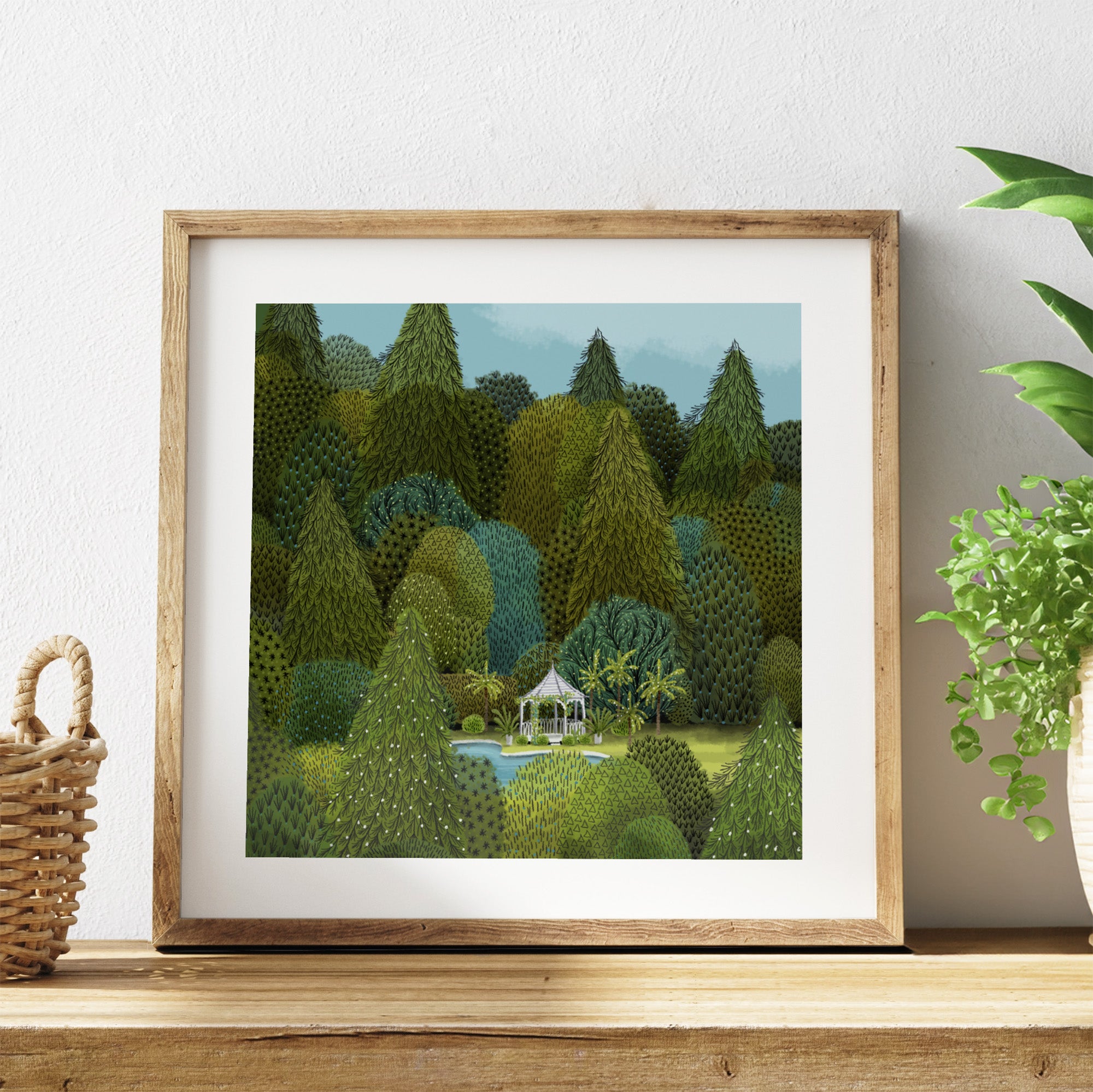 Framed artwork of a forest scene on a wooden shelf with a plant and basket.
