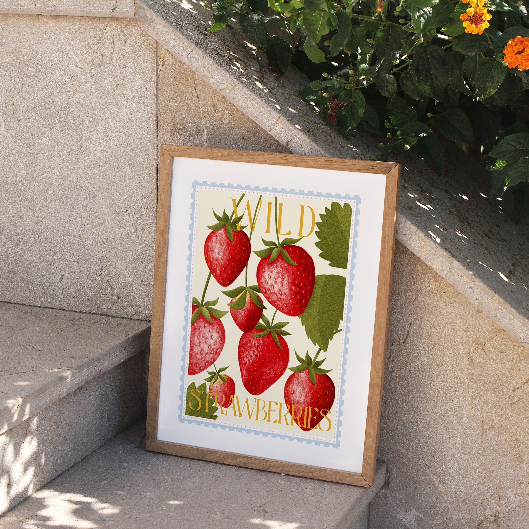 Framed artwork of strawberries on a stone ledge with plants in the background.