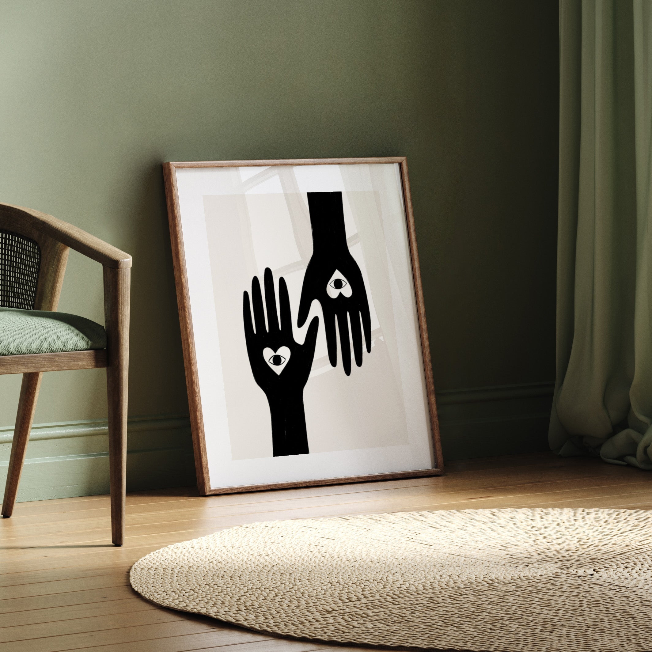 Framed artwork of two hands with heart symbols on a wall in a room with a chair and rug.