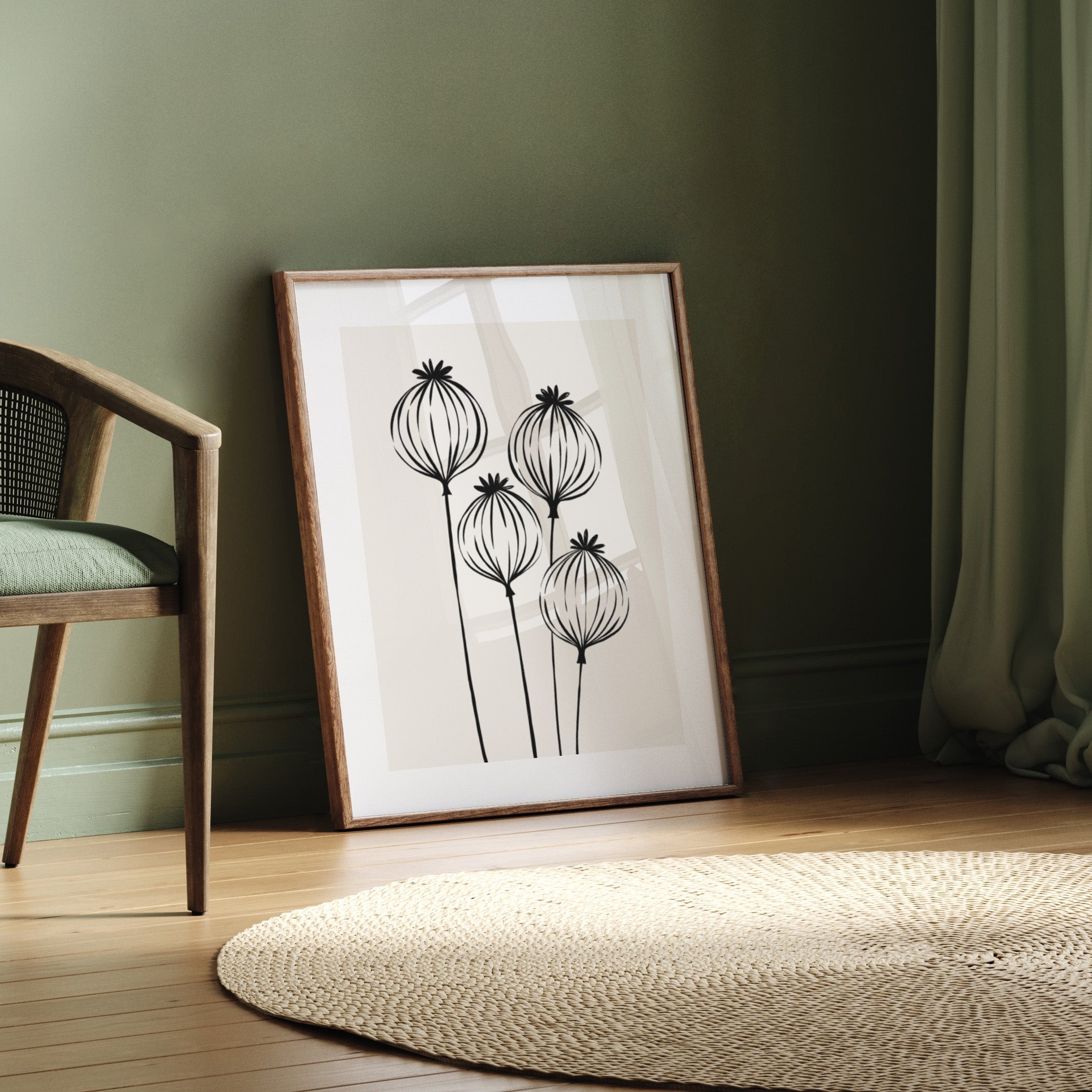 Framed artwork with floral design on a wooden floor against a green wall.