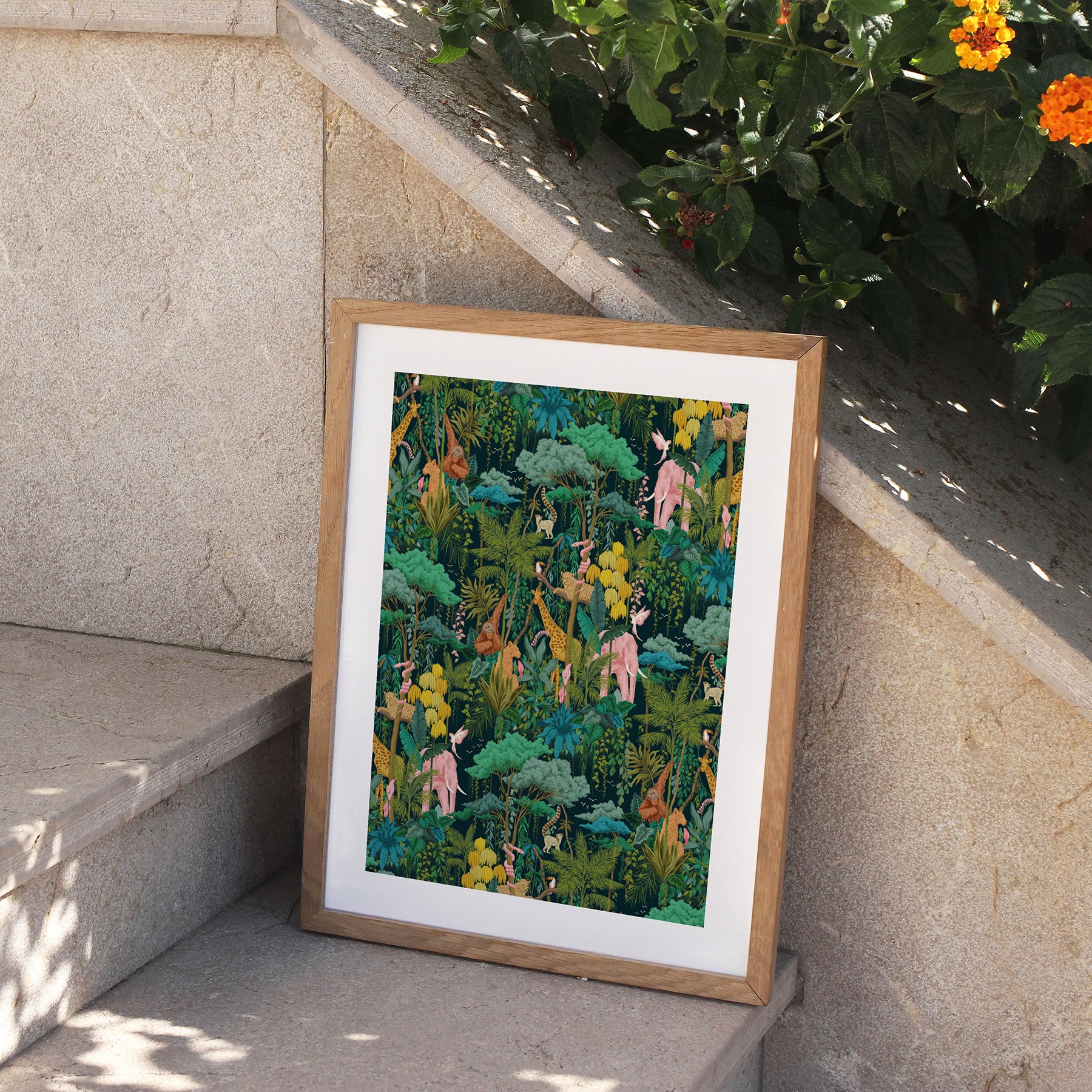 Framed artwork of a colorful forest scene on a stone ledge with plants in the background.
