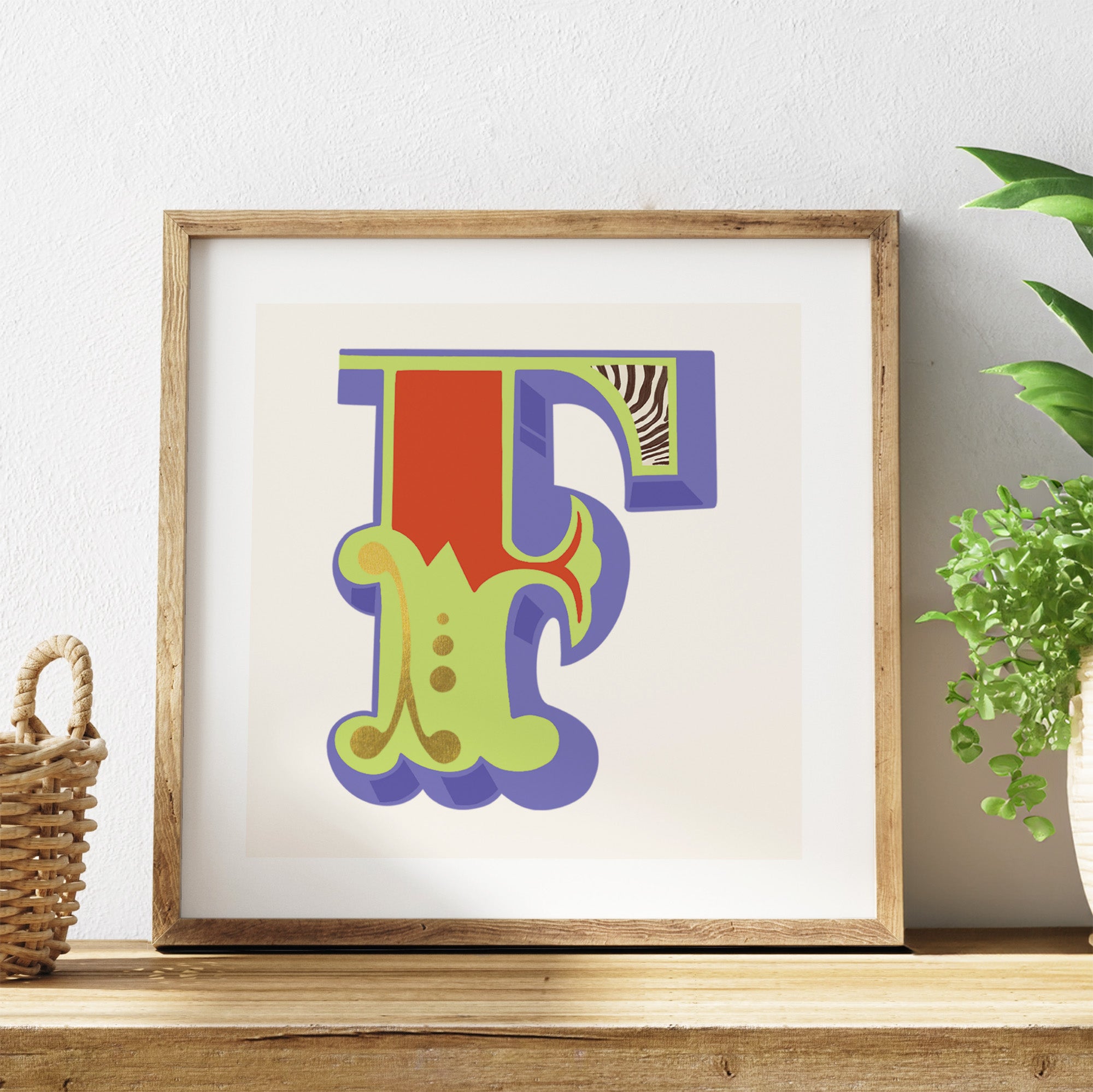 Framed colourful letter 'F' artwork on a shelf with a plant and basket in the background.