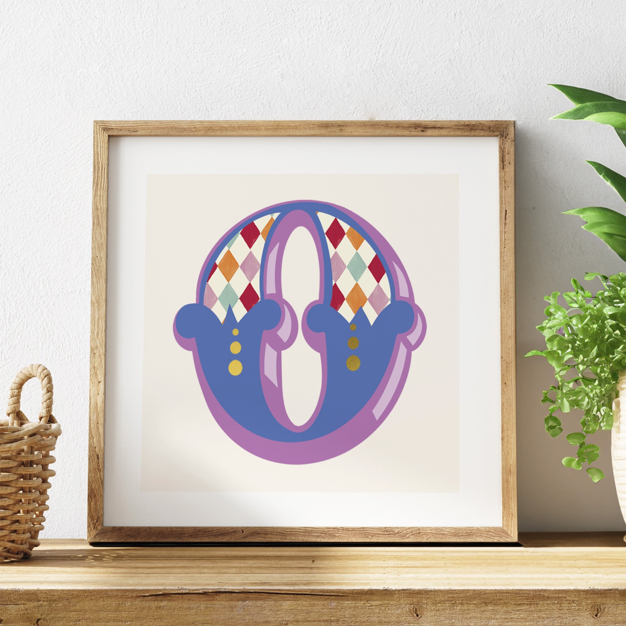 Framed colourful letter 'W' art piece on a shelf with a plant in the background.