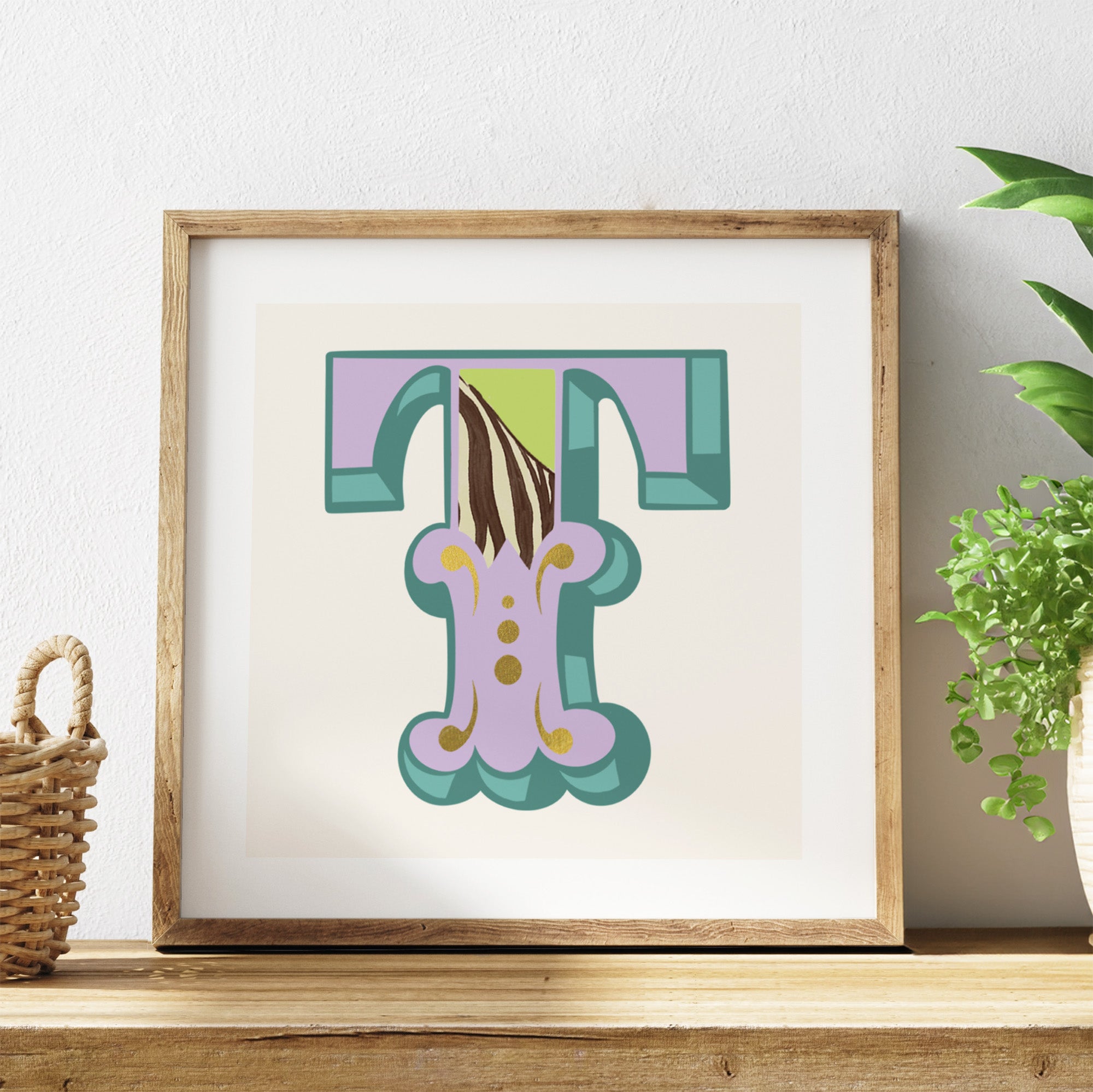 Framed artwork with a colourful letter 'T' on a white background.